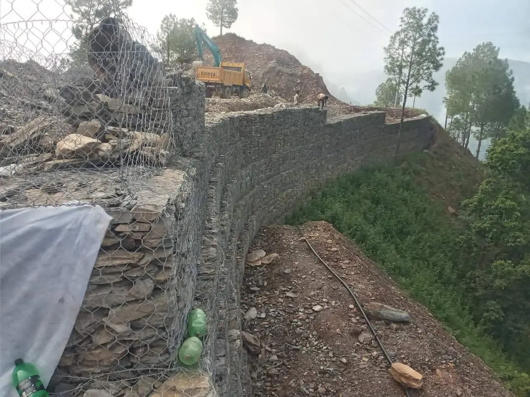 Stepped gabion retaining wall under construction on a hillside in Nepal